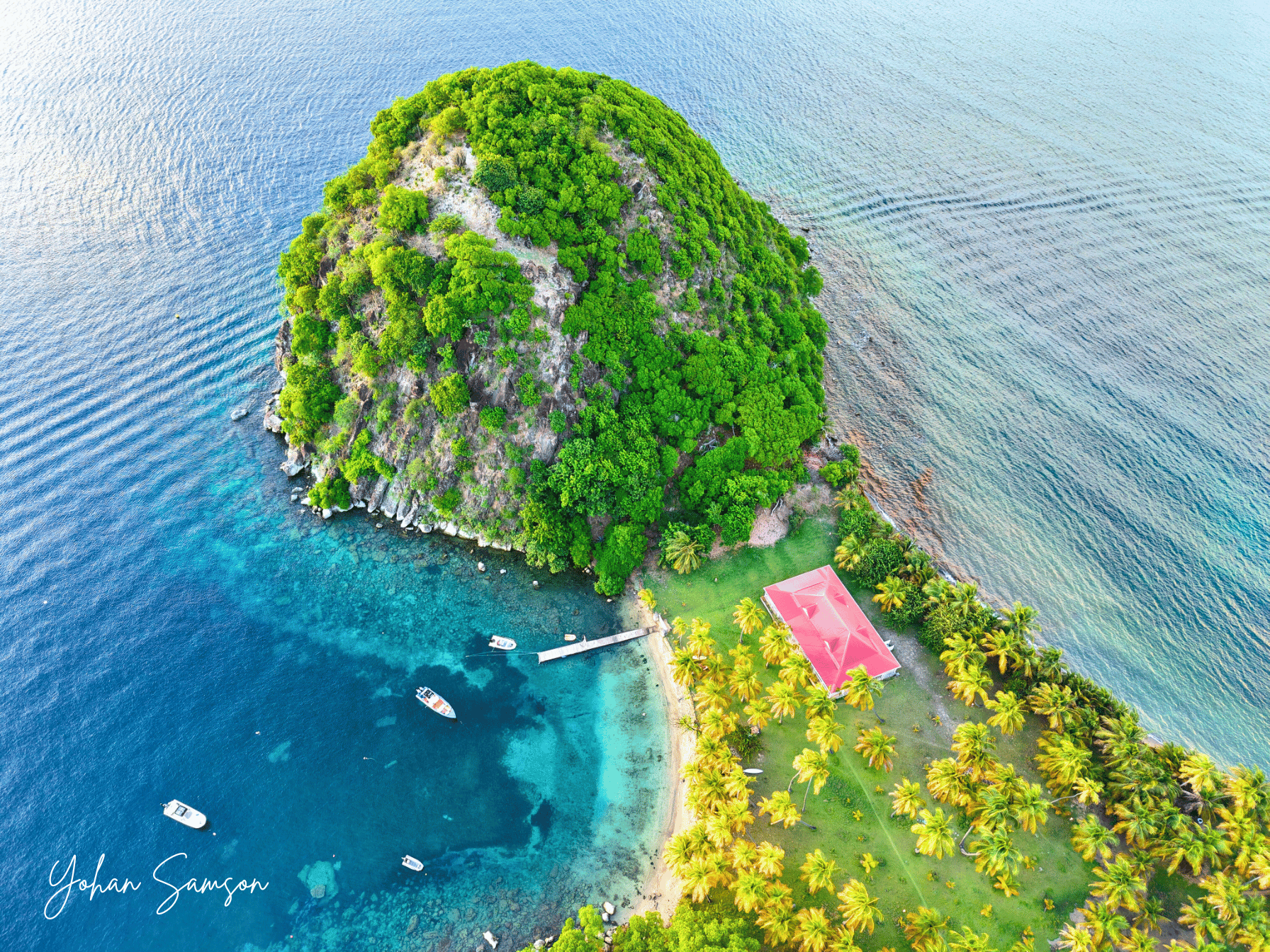 Plage du Pain de Sucre à Terre-de-Haut avec eau cristalline et relief volcanique